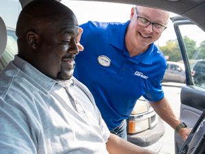 Car-Mart associate helping a customer sitting in a car.