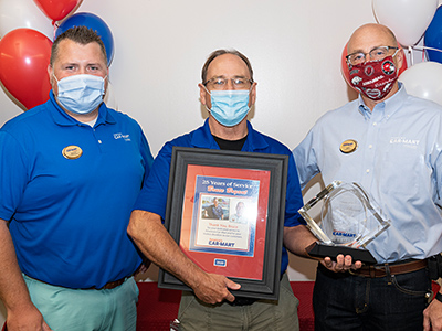 Bruce Bryant at his 25 years of service Car-Mart party with Bruce Lynch, VP of Inventory Operations, and Jeff Williams, CEO